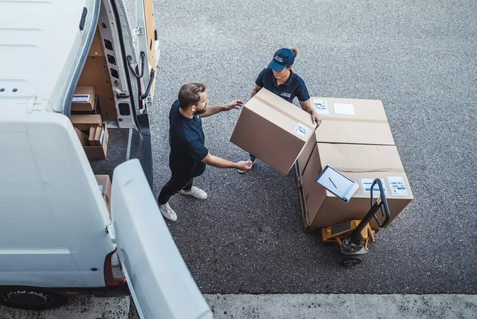 Delivery team loading palletised boxes into a van
